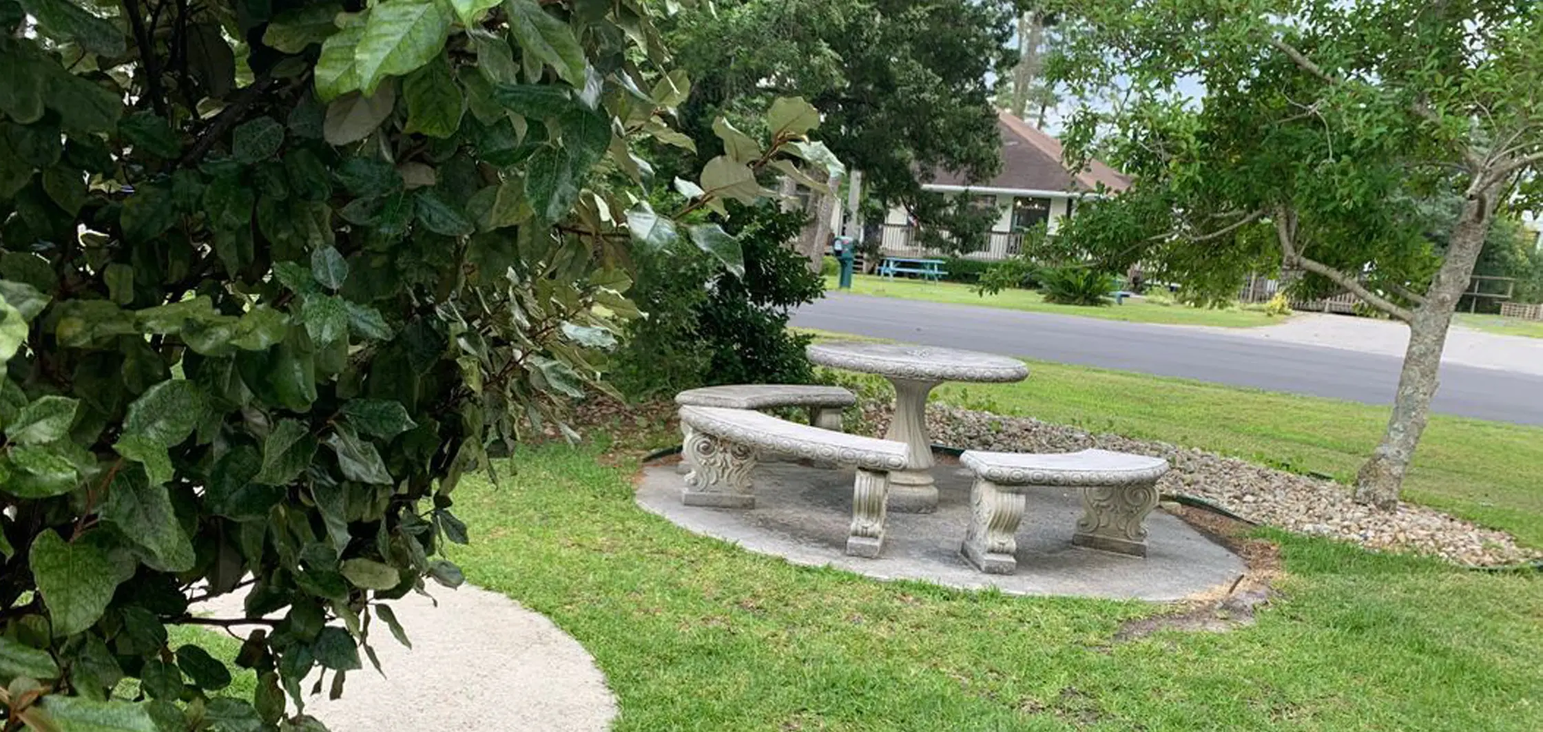 A stone picnic table and bench under trees on the inn's grounds